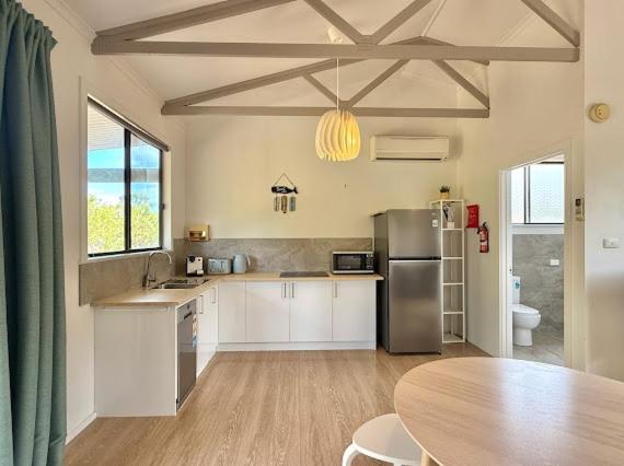 a kitchen with a table and a refrigerator and a dining room at Beachside Cabin No 2 at Island Beach in Island Beach