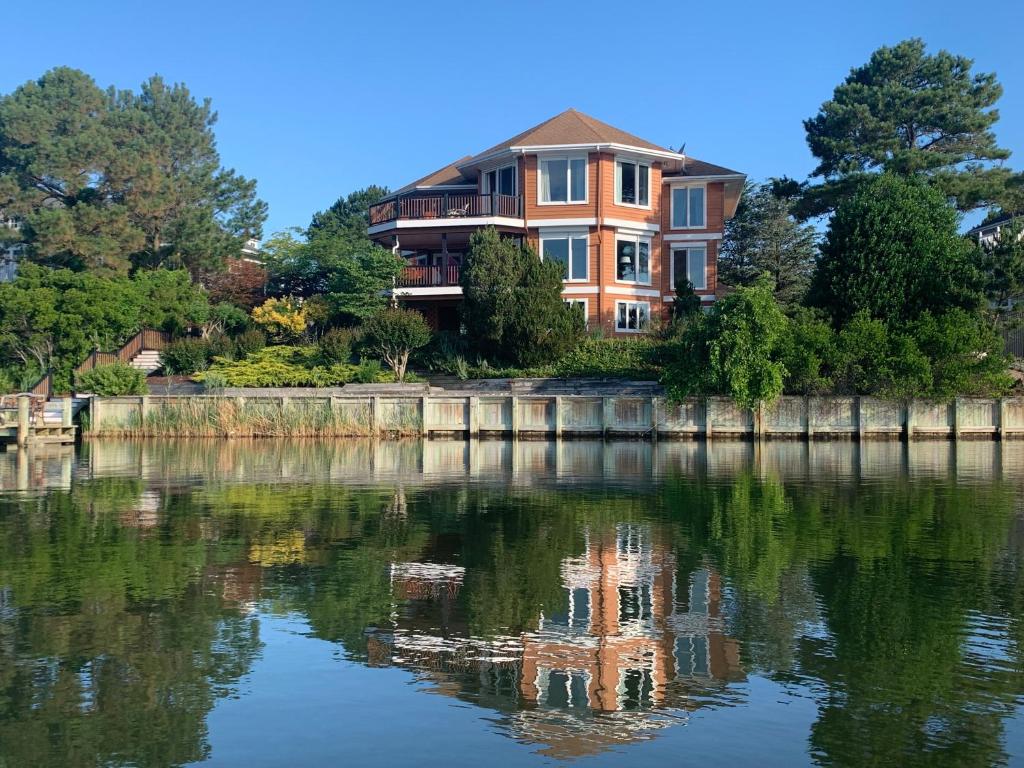 a large house sitting on the side of a lake at Family Vacation Home - Stunning Views across Salt Pond in Bethany Beach
