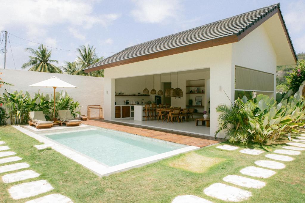 a house with a swimming pool in front of it at Summer Promo - 2 BR villa, big pool & garden in Kuta Lombok