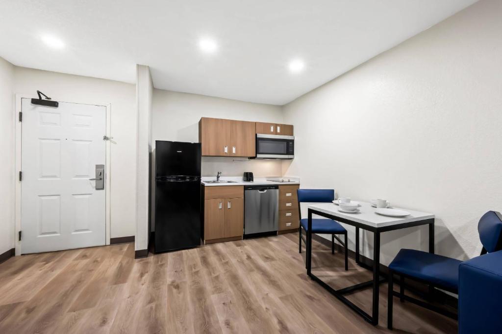 a small kitchen with a table and a refrigerator at MainStay Suites Raleigh North in Raleigh