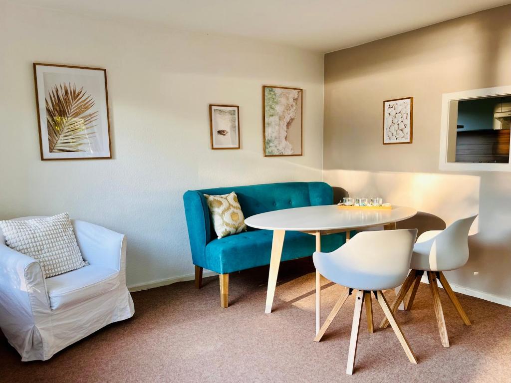 a living room with a table and a blue couch at Opa Meyer in Glücksburg