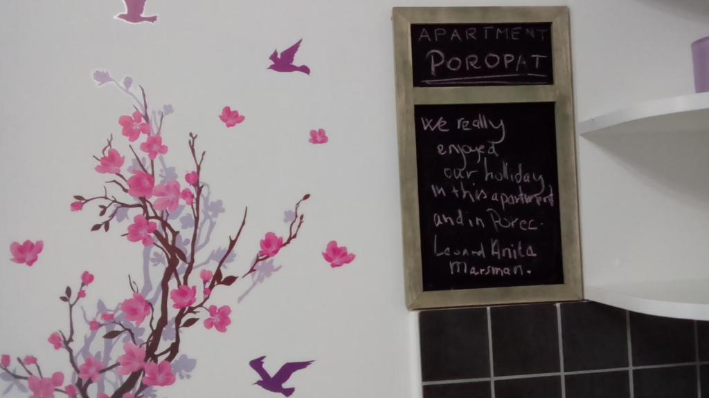 een bord in een badkamer met vlinders aan de muur bij Apartment Poropat in Poreč