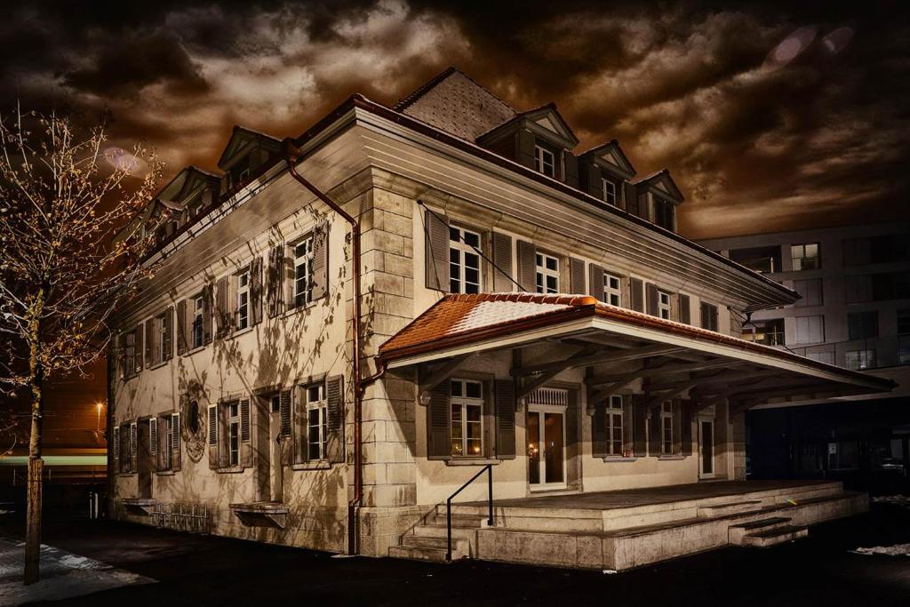 an old building is lit up at night at Boutique Hotel Spedition a member of DESIGN HOTELS in Thun