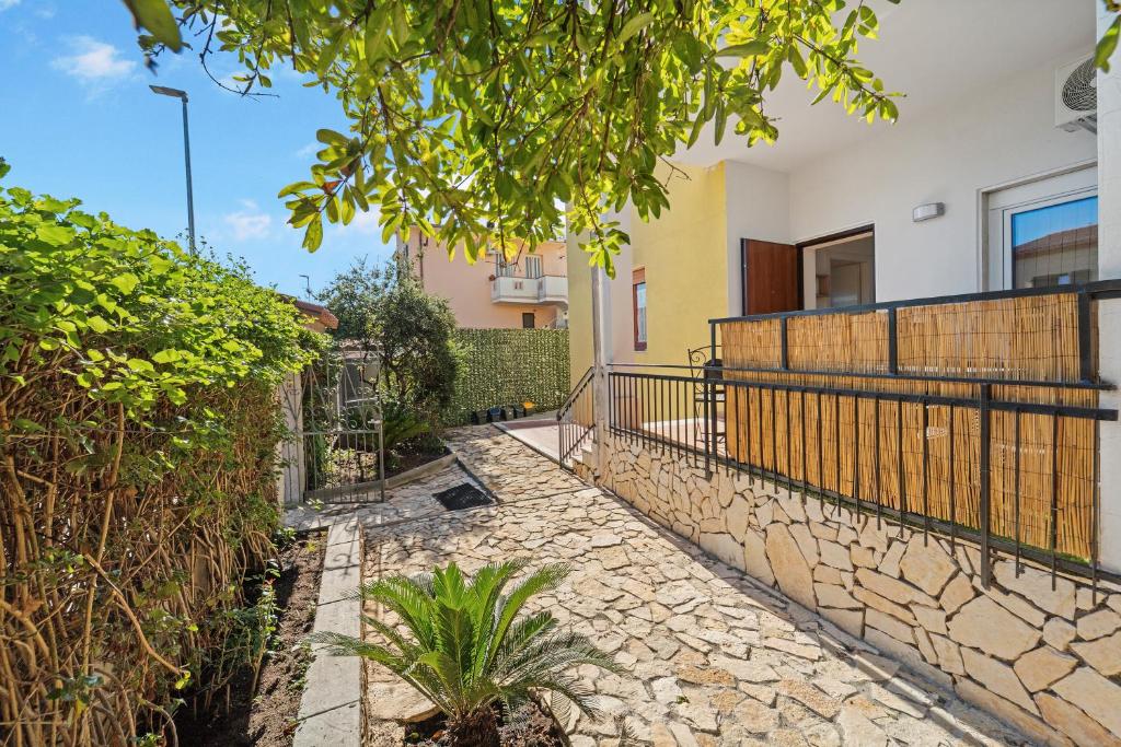 a stone path in front of a house with a fence at Appartamento Matteo in Pula