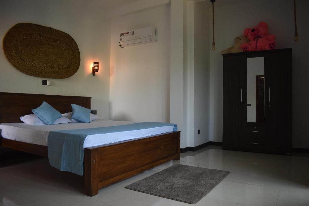 a bedroom with a bed with blue pillows at New View Hikkaduwa in Hikkaduwa