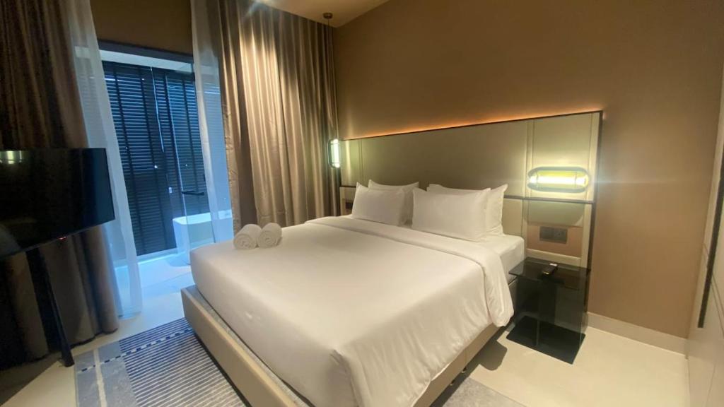 een groot wit bed in een kamer met een raam bij New This is in Genting Highland hill -12mins walk 4pax in Genting Highlands