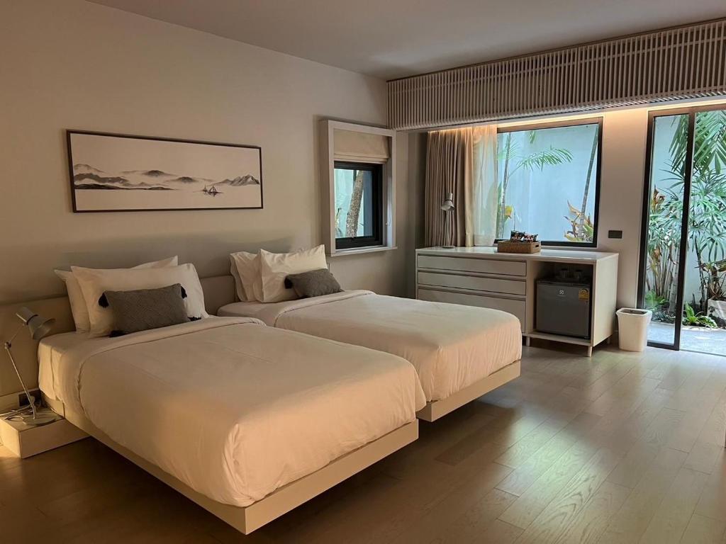 um quarto com duas camas e uma televisão em Tree Villa Bangkok em Banguecoque