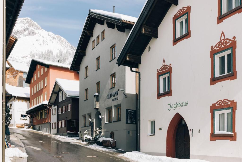un edificio en una calle con una montaña en el fondo en Das Johann, en Stuben am Arlberg