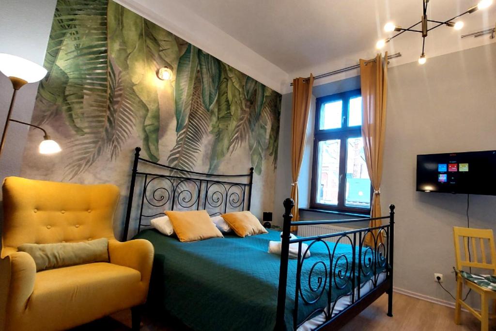 Un dormitorio con una cama y una silla amarilla. en Cozy Old Town Apartments, en Cracovia