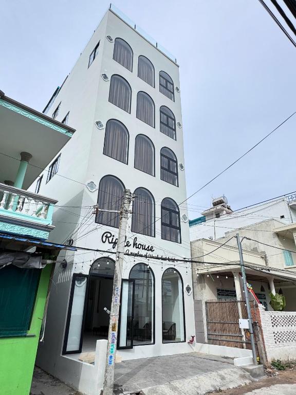 a white building with a sign that reads city is house at Ripple house in Ấp Thiện Sơn