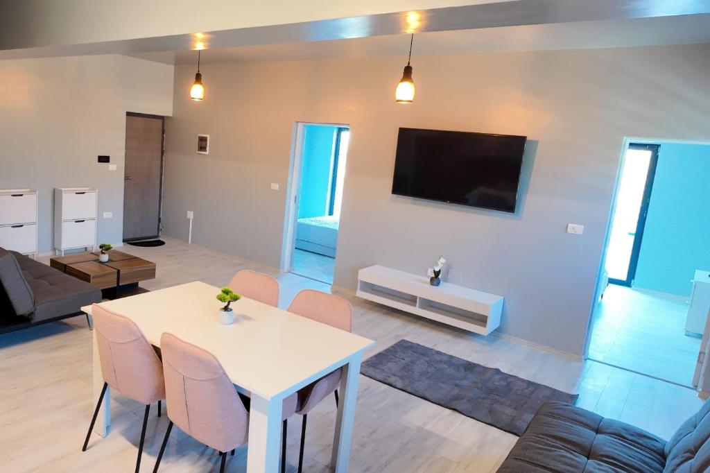 a living room with a white table and chairs at Apartament via carmina in Văleni