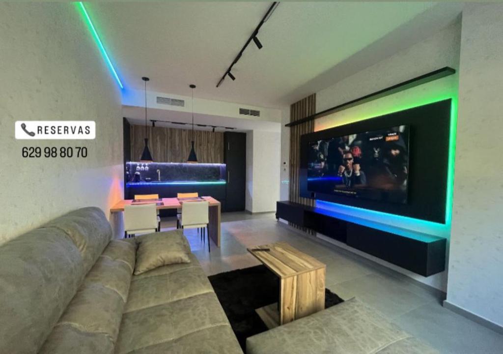 Una sala de estar con un sofá y un televisor de pantalla plana. en Lujo en el centro con parking privado 1, en Adra