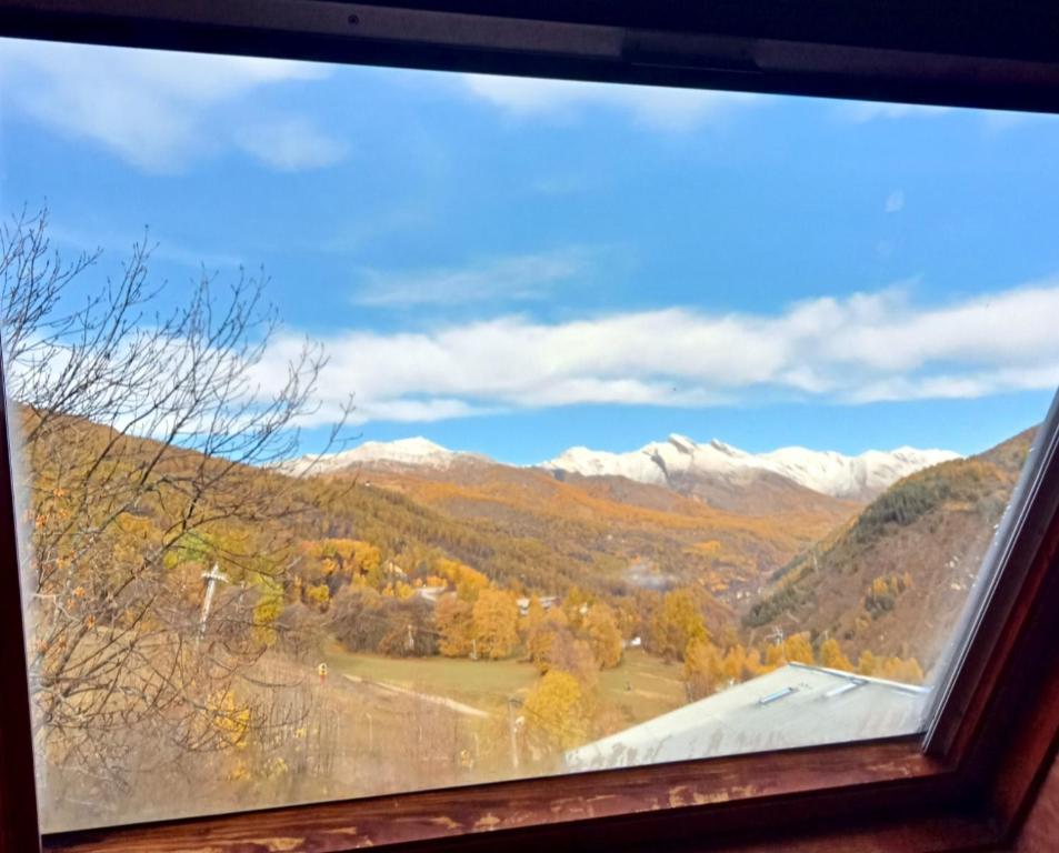 a view of the mountains from a window at joli studio vue montagne in Allos