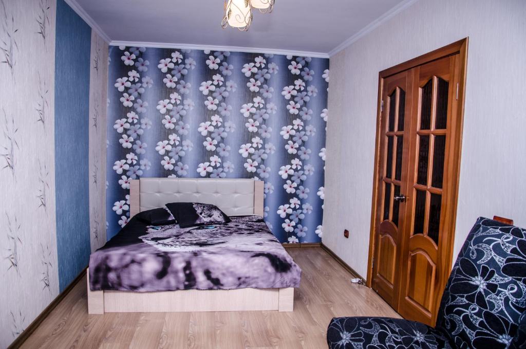 トリヤッチにあるApartment on Miraのベッドルーム1室(ベッド1台付)、青い壁(花付)