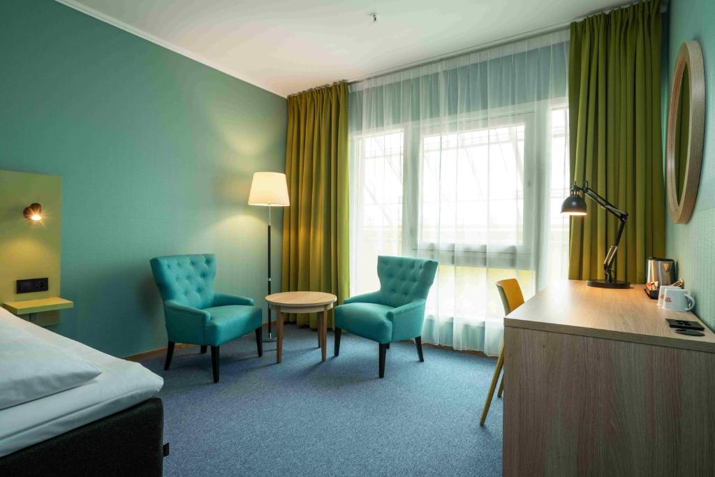 a hotel room with a bed and a table and chairs at Thon Hotel Verdal in Verdal