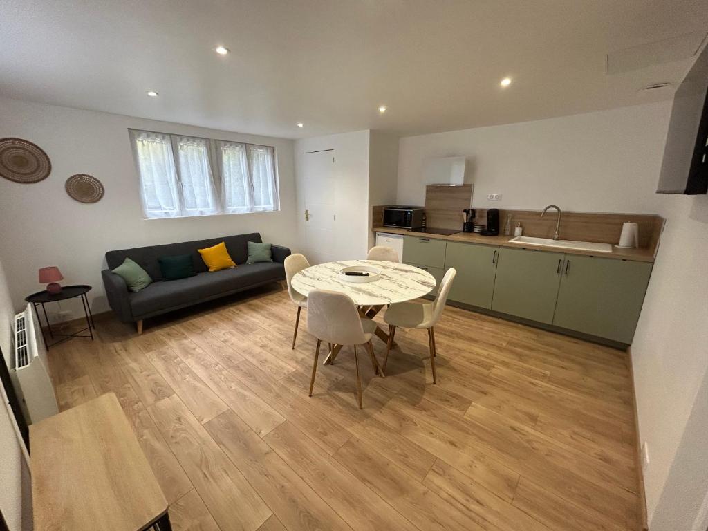a kitchen and a living room with a table and chairs at Appartement au calme in Saint-Denis-sur-Loire