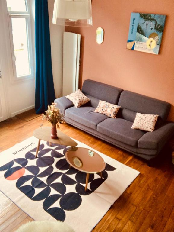 a living room with a couch and a table at La petite Maison in Pougues-les-Eaux