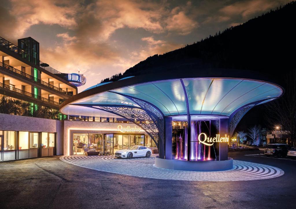 a white car parked in front of a building at Quellenhof Luxury Resort Passeier in San Martino