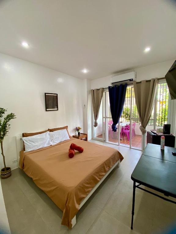 a bedroom with a bed with a red stuffed animal on it at Villa Talisay Kaputian - Streetside Studio in Samal