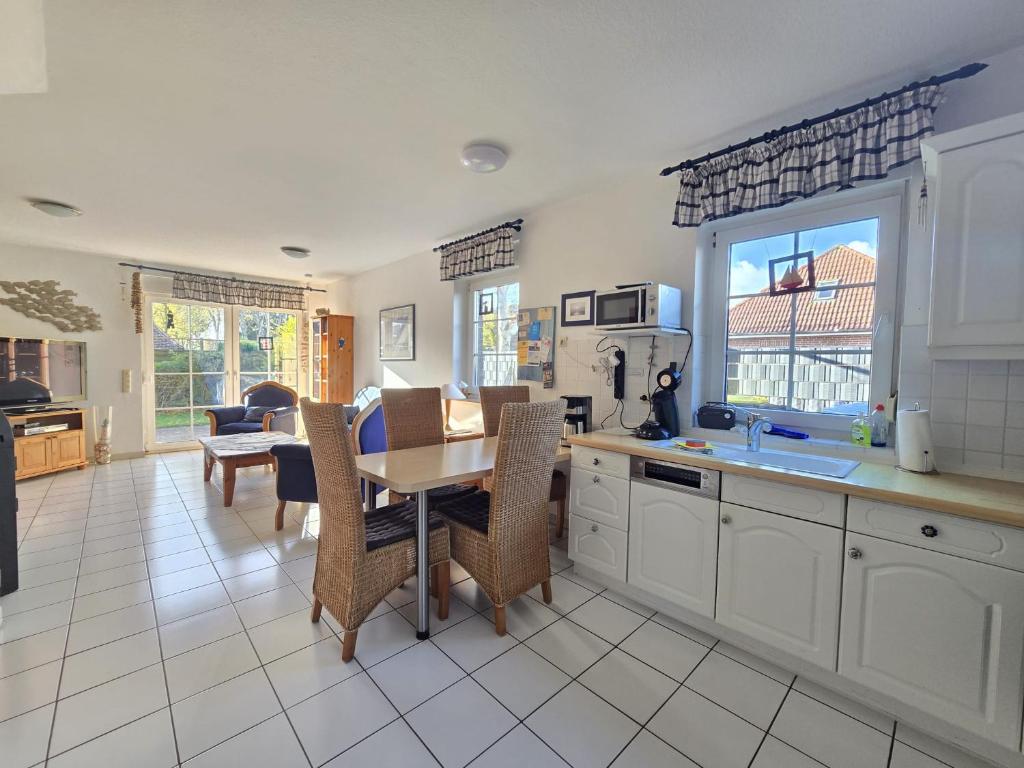 Nordseeferienhaus Ehlers في نيسمارزييل: مطبخ وغرفة طعام مع طاولة وكراسي