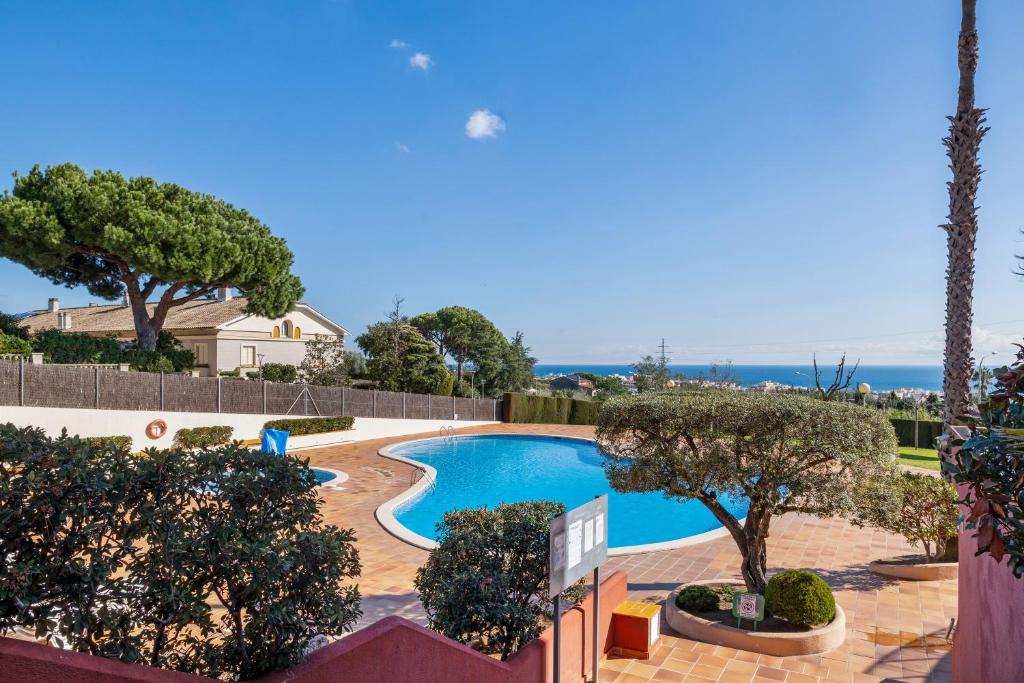 a swimming pool with trees and the ocean in the background at Host Dalies in San Pedro de Premiá