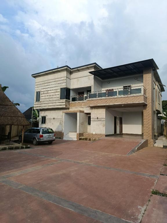 a building with a car parked in a parking lot at Private home with short lets in Uyo