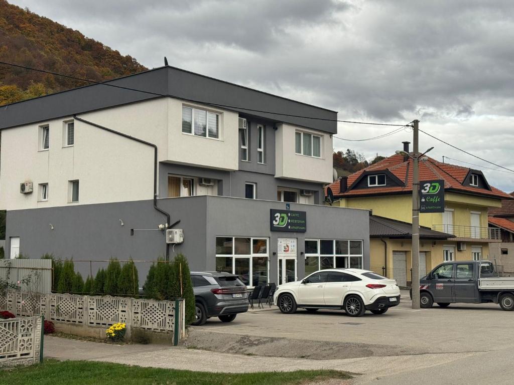 Dobrinjeにある3D Caffe Apartmaniの駐車場に車が駐車されている建物