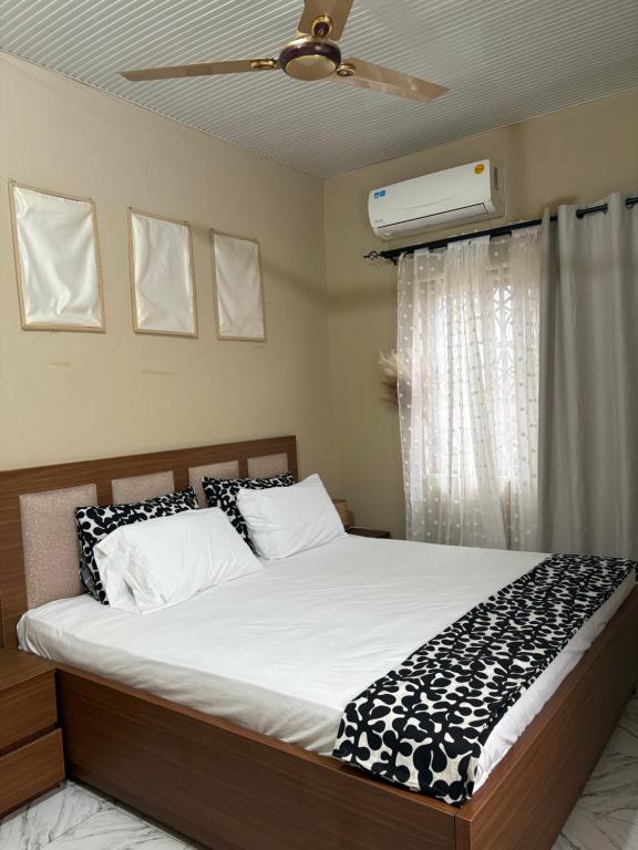 Un dormitorio con una cama y un ventilador de techo. en Kasoa Stay, en Kasoa