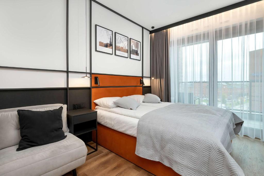 een hotelkamer met twee bedden en een stoel bij Elegant Studio with Air Conditioning Pet Friendly by Noclegi Renters in Suchanino