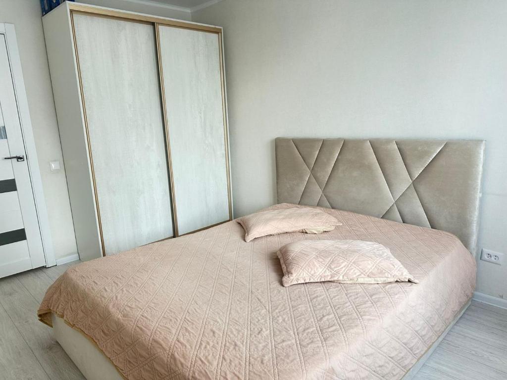 - une chambre avec un lit avec une tête de lit et deux oreillers dans l'établissement New! 2-комнатная квартира В САМОМ ЦЕНТРЕ ГОРОДА, à Petropavlovsk-Kamtchatski