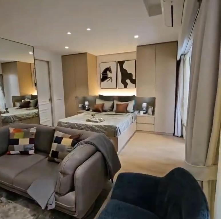 a large bedroom with a bed and a couch at Petal Stays - Just 1 Km from Airport in Pune