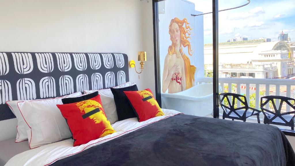 a bedroom with a bed with colorful pillows on a balcony at Kunst in Bangkok