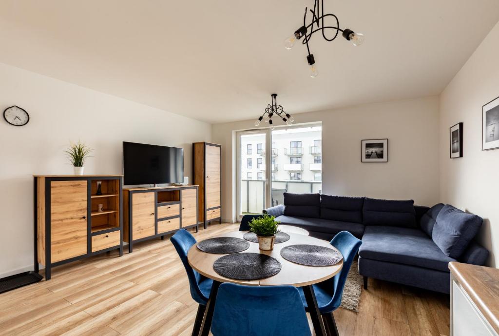 een woonkamer met een bank en een tafel bij Nasypowa Spacious Apartment by BookingHost in Gdynia