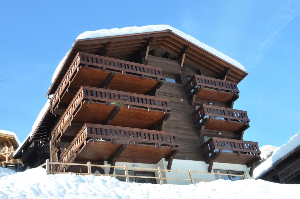 a building with wooden balconies in the snow at Chateaupré D 01 in Grimentz