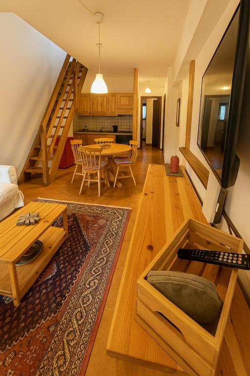 a living room with a table and a staircase at SkiLift Tarvisio Apartment Free Parking in Tarvisio