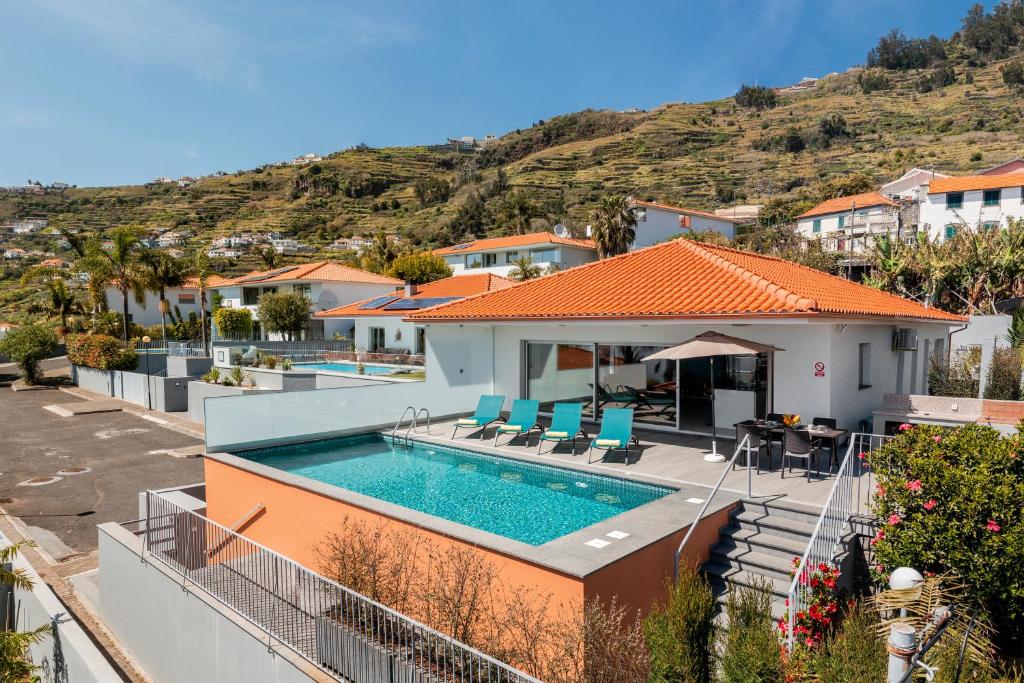 eine Villa mit Swimmingpool und ein Haus in der Unterkunft OurMadeira - Arco Sun in Arco da Calheta
