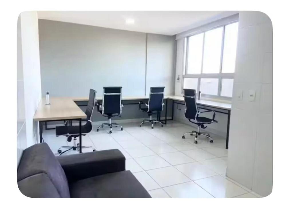 uma sala de conferências com uma mesa e cadeiras e um sofá em StudioPremium Hospedagem EventosCorporativosAnhembi ExpoCenterNorte em São Paulo
