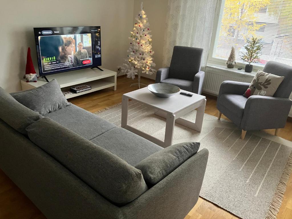 - un salon avec un canapé et un arbre de Noël dans l'établissement Skandinavian City home 76m2, à Rovaniemi