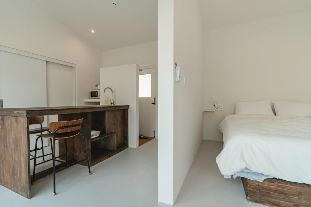 a bedroom with a bed and a desk and a bed at Jeju Mureungri The house in Murŭng-ni