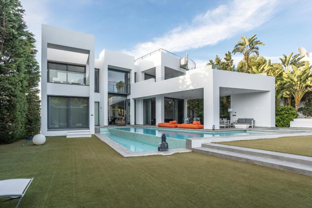 a large white house with a swimming pool at Villa Elite Maribiza in Cala Llenya