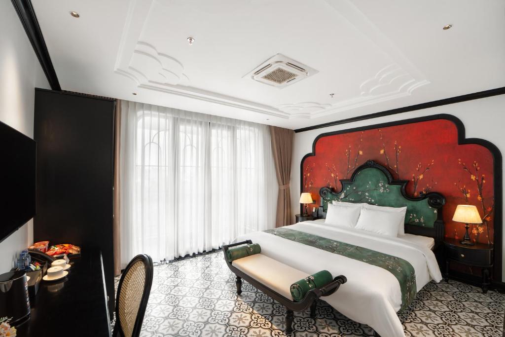 a bedroom with a large bed with a red wall at C'Lau Hotel Ninh Binh in Ninh Binh