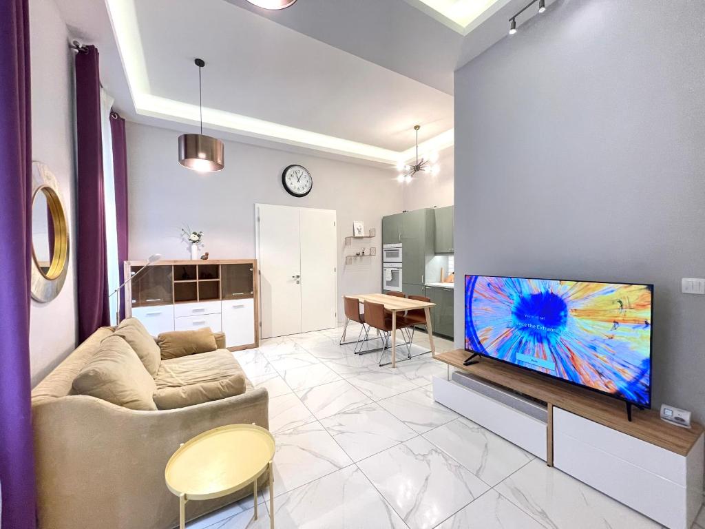 a living room with a couch and a tv on a wall at 布达城堡链子桥公寓民宿 in Budapest