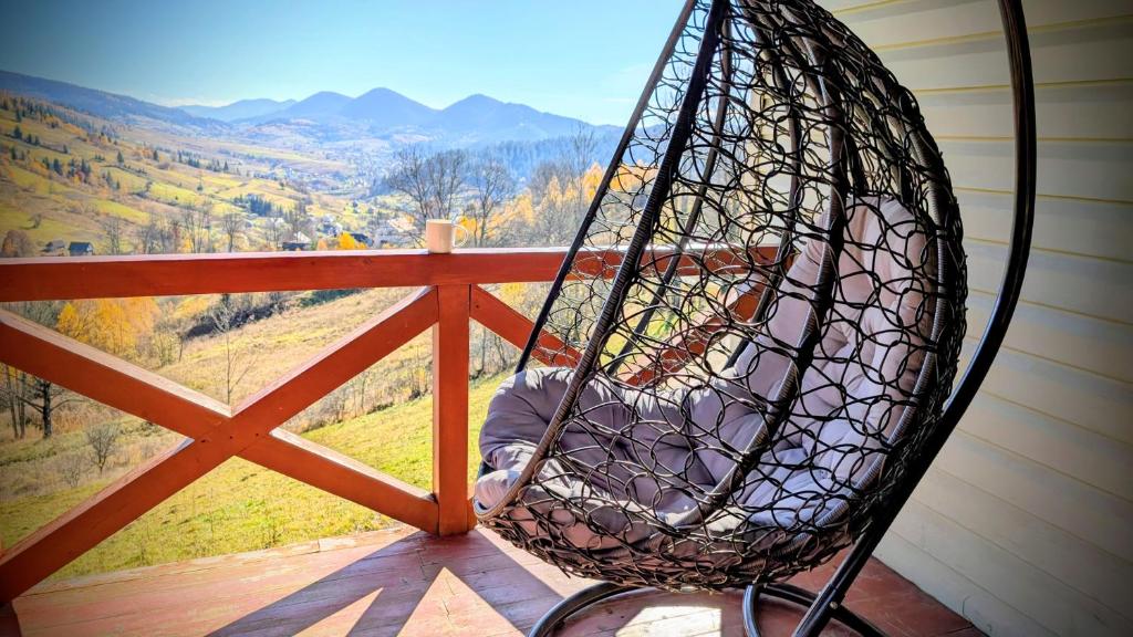 a person sitting in a swing on a porch at Green House Panorama Karpat in Volosyanka