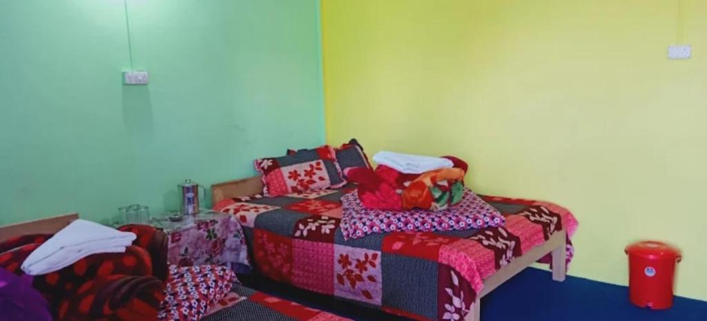 a bedroom with a bed with a comforter on it at Brookland Stays in Pedong