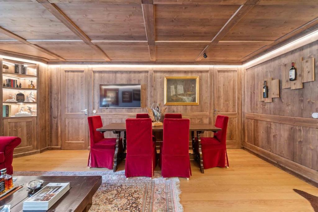 a dining room with a table and red chairs at St Moritz Square 2 bedr Alpin Elegance in St. Moritz