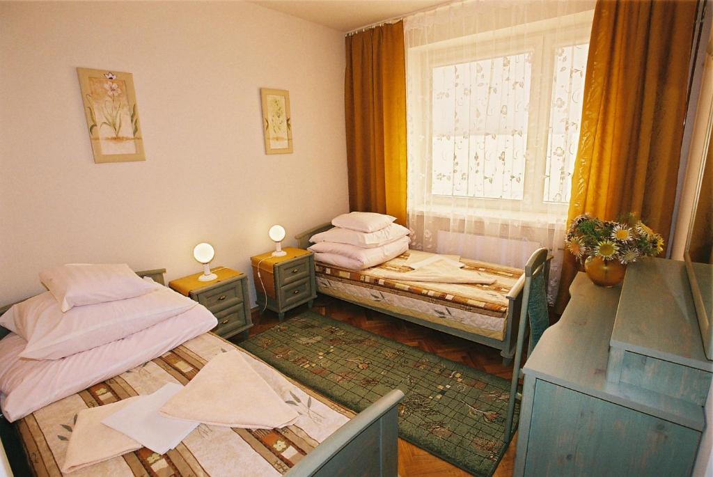 2 Einzelbetten in einem Zimmer mit Fenster in der Unterkunft Jawor in Polańczyk
