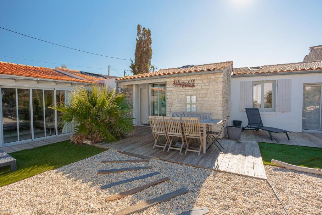 a patio with a table and chairs in a yard at Villa L’hirondelle in La Michelière