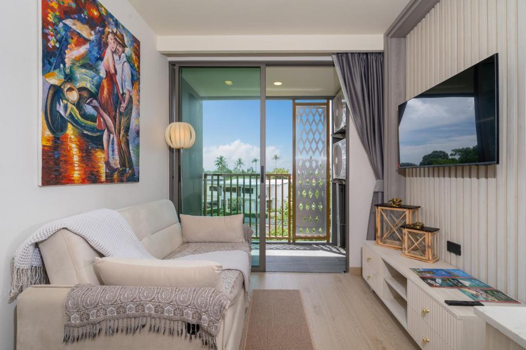 a living room with a couch and a painting on the wall at Ozone Condominium BangTao Laguna Area in Phuket