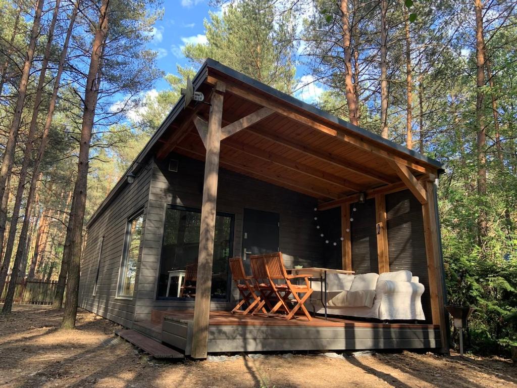a cabin in the woods with a table and chairs at Lukasowy domek w Puszczy Noteckiej in Biala