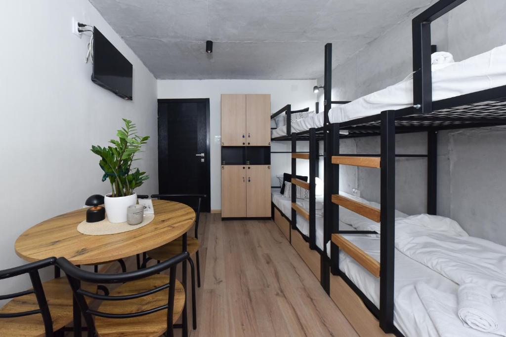 a room with a dining table and bunk beds at Industrial Hostel Vila Jovana in Odžaci